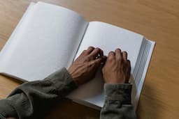 mains sur un livre en braille
